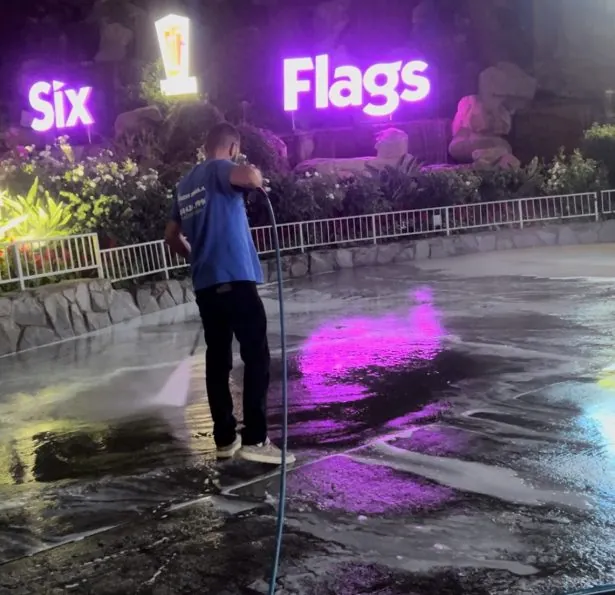Fresh Bins LA crew member pressure washing a commercial walkway at night